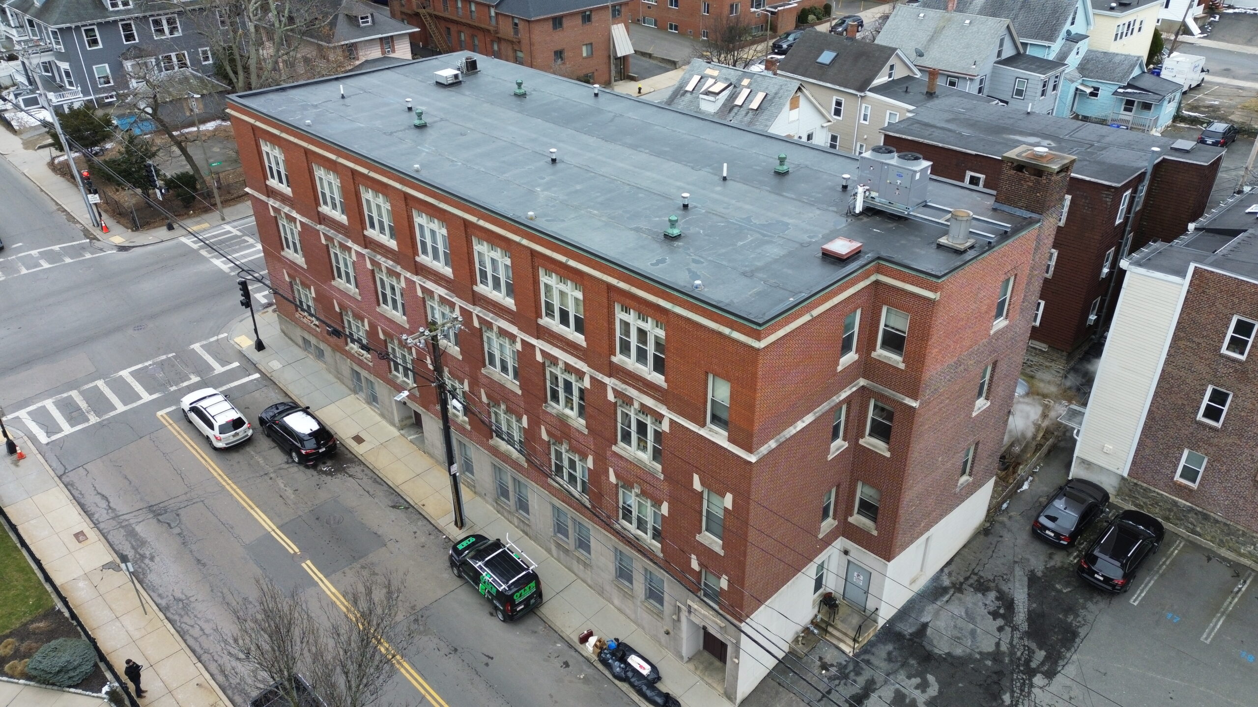 Angled view of a new commercial flat roof on a large brick building in downtown Brighton, MA.